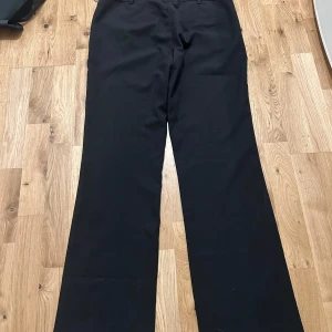 Svarta kostymbyxor från Bik Bok - Klassiska svarta kostymbyxor från Bik Bok med rak passform och normal midja. 