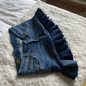 Jeanskjol med volang - Kort jeanskjol med volang i kanten😚 kom gärna med prisförslag! Längden fram är 25cm och bak 35cm, midjemåttet är 37cm i knapphöjd😊 
