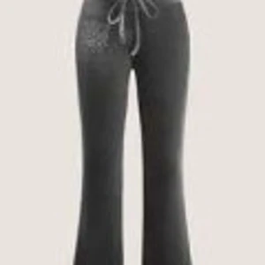 Grå ribbade mjukisbyxor med snörning - Gråa mjukisbyxor med ribbad struktur och utsvängda ben. Byxorna har en dragsko i midjan för justerbar passform och är perfekta för en avslappnad stil.