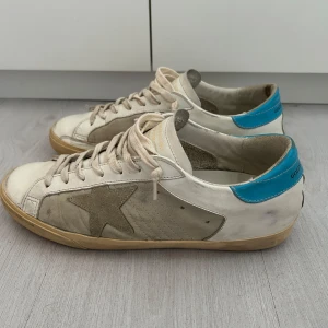 Golden Goose skor  - Säljer ett par vita sneakers från Golden Goose. Skorna är i storlek 43. Skorna är i bra skick och har inte använt de mycket. Modellen ska även se sliten ut. Säljer för att de inte riktigt passade och vill bara bli av med de. Hör av dig vid frågor! 