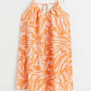 Orange och vit mönstrad klänning - Säljer en somrig klänning med orange och vitt zebramönster. Klänningen är ärmlös med smala axelband och aldrig är använd❤️‍🔥