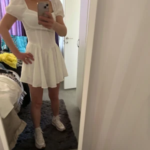 Student eller fest klänning  - Säljer en söt vit klänning med puffärmar och en tight passform upptill. Klänningen har en kort längd och en vacker struktur i tyget. Perfekt för sommarens alla tillfällen! 💫