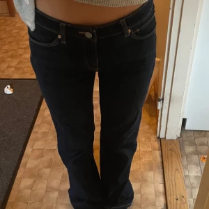 Mörkblå bootcut jeans - Snygga mörkblå bootcut jeans från abrand med låg midja. Klassisk design med fem fickor och knappgylf. Perfekta för en avslappnad stil.