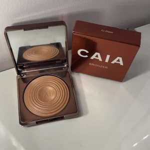 Bronzer från CAIA - Snygg Caia bronzer i färgen la digue. Jag säljer för att den är för ljus för mig. Och jag har bara testat den med borste så därför ser man att den har ett litet tecken på användning. Den ger er glowig sol kysst lock 💖💖