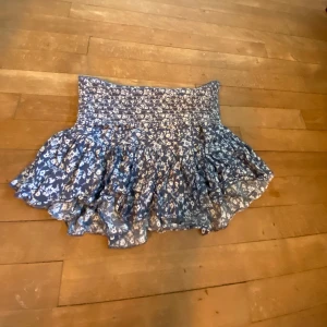 Blå blommig volangkjol - Blå och vit volangkjol, som ny!! Går att vika ner i midjan om man vill, super stretchig💘