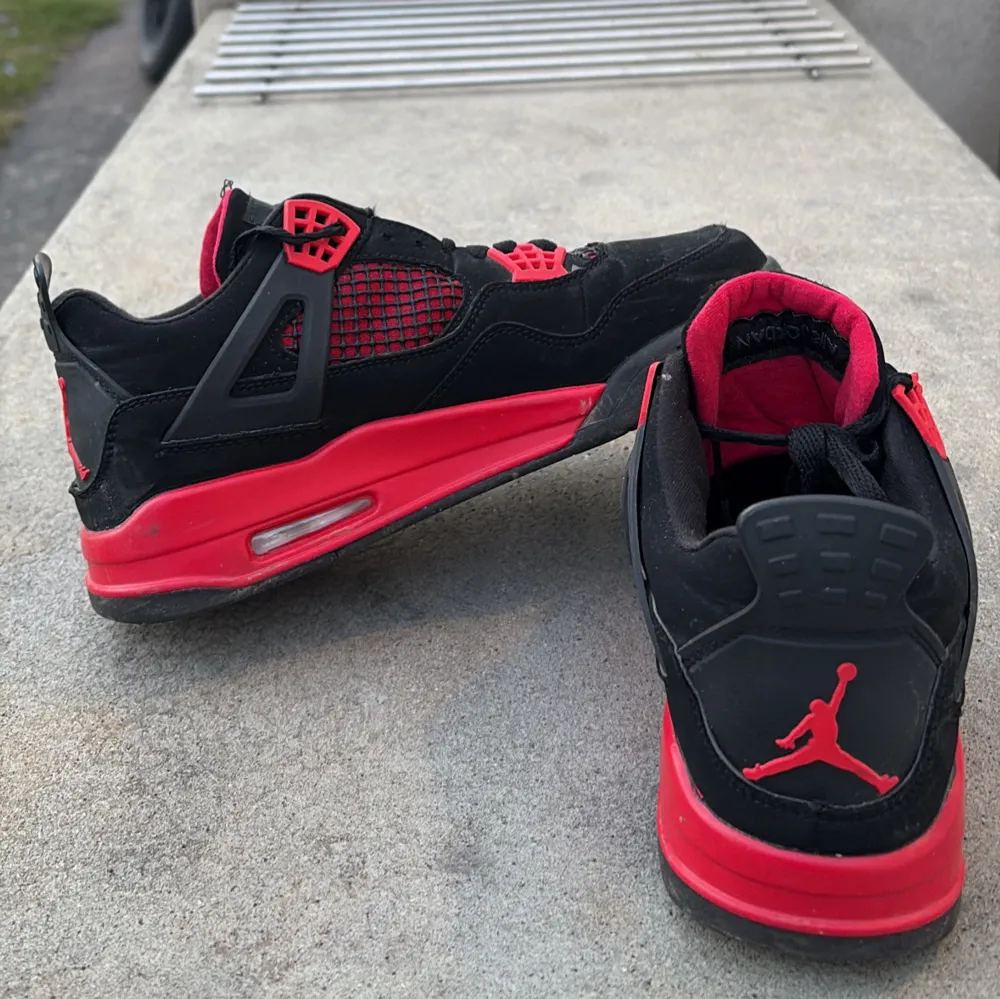 Säljer ett par snygga Nike Air Jordans i svart och rött. Skorna har en ikonisk design med Jumpman-loggan på tungan och hälen. De är tillverkade i mocka med detaljer i syntet och har en bekväm passform med snörning.. Kengät.