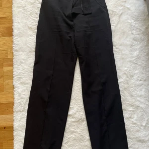 Svarta kostymbyxor från Madlady -  Svarta kostymbyxor från Madlady med pressväck fram och rak passform.