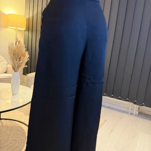 Svarta vida byxor - Snygga svarta byxor med hög midja och en vid passform. Perfekta för en stilren look. Byxorna är tillverkade i ett mjukt material som ger en bekväm känsla hela dagen. Passar perfekt som oversize modell.🌸👌