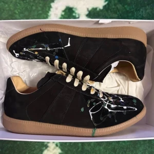 Maison Margiela - Unika svarta sneakers från Maison Margiela med färgstänk i olika färger. Galet snygg sko nu till våren! Skorna är andvända fåtal gånger och i mycket fint skick!