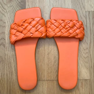 Orange flätade sandaler - Snygga orange sandaler med flätad rem. Perfekta för sommardagar och ger en färgglad touch till din outfit.