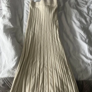 Beige ribbad kjol från Gina Tricot - Säljer en stilren beige ribbad kjol från Gina Tricot i storlek XS. Kjolen har en lång och elegant design med en elastisk midja för en bekväm passform. Perfekt för en chic och minimalistisk look.