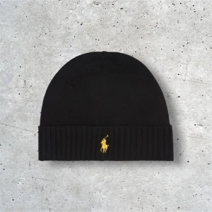 Ralph lauren mössa - Skick: 10/10 . Har andvänt 3 gånger. Svart med en stilren broderad guldig logs på mitten av mössan