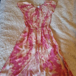 Rosa och gräddvit fläckig klänning - En luftig rosa klänning som passar perfekt i värmen. Jag säljer den för den inte passar längre. Den har även shorts under klänningen  som inte syns så mycket fram i från.