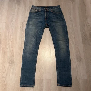 Nudie Jeans - Säljer ett par klassiska blå jeans från Nudie Jeans. De har en normal passform med en rak stil och är tillverkade i denim. De är storlek W 31 L 30 och jag ör 176 o väger 63 kg o de sitter perfekt på mig, bra skick! Hör av dig vid minsta fundering!