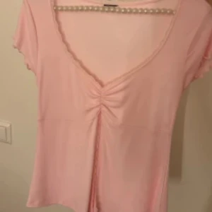 Rosa topp från Gina Tricot - Säljer en söt rosa topp från Gina Tricot med korta ärmar och v-ringning. Storlek S, PM vid frågor 