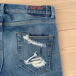Blå jeans från Dondup - Snygga blå jeans från Dondup med slitna detaljer och fransade benslut. De har en klassisk femficksdesign och en cool, avslappnad look. Perfekta för en trendig stil. Storlek W30L30. Nypris på dessa är runt 3000kr och ganska svåra att få tag på till ett bra pris. Jeansen är i mycket bra skick och otroligt bekväma! Hör av dig vid fundering mvh Levi!