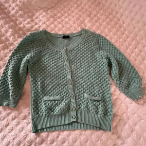 Mintgrön kofta från F&F - Säljer en söt mintgrön kofta från F&F med ett fint stickat mönster. Koftan har trekvartsärmar och knappar framtill. Perfekt för vår och sommar! Säljer då den aldrig kommit till användning.