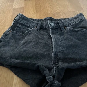 Svarta vintage modell shorts i stl. 36 - Säljer ett par svarta vintage shorts i denim med hög midja. De har en klassisk femficksdesign och knappgylf. Perfekta för en avslappnad stil.