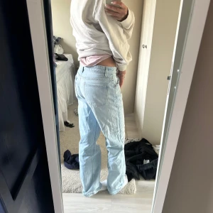 Ljusblå jeans - Snygga ljusblå jeans med en klassisk straight passform. De har en hög midja och är perfekta för en avslappnad stil. Jeansen har traditionella fem fickor och en dragkedja med knappstängning.