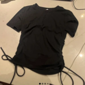 Svart t shirt från Zara - Säljer en svart kortärmad topp från Zara med snörning i sidorna för en justerbar passform 🖤