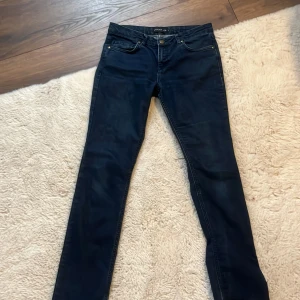 Vintage low waist jeans STOCKH LM - Snygga lågmidjade mörkblå jeans från STOCKH LM med en klassisk femficksdesign. De har en rak fast lite lite bootcut och skrynklig nere vid bena passform och skulle nog passa perfekt för någon som är mellan 160-170cm, men beror såklart på hur du vill ha dina jeans. Jeansen är tillvärkade i slitstarkt denimtyg och är i bra skick förutom att dem har en liten skråma där bak vilket du ser på sista bilden, men går enkelt att fixa! Det står storlek 40 men passar perfekt på mig som vanligtvisst har S. 