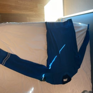 Blå tröja från Stone Island - Säljer en snygg blå tröja från Stone Island med deras ikoniska märke på ärmen. Tröjan har långa ärmar och är perfekt för en stilren look. Passar bra till både jeans och chinos. Stickat/cashmere 