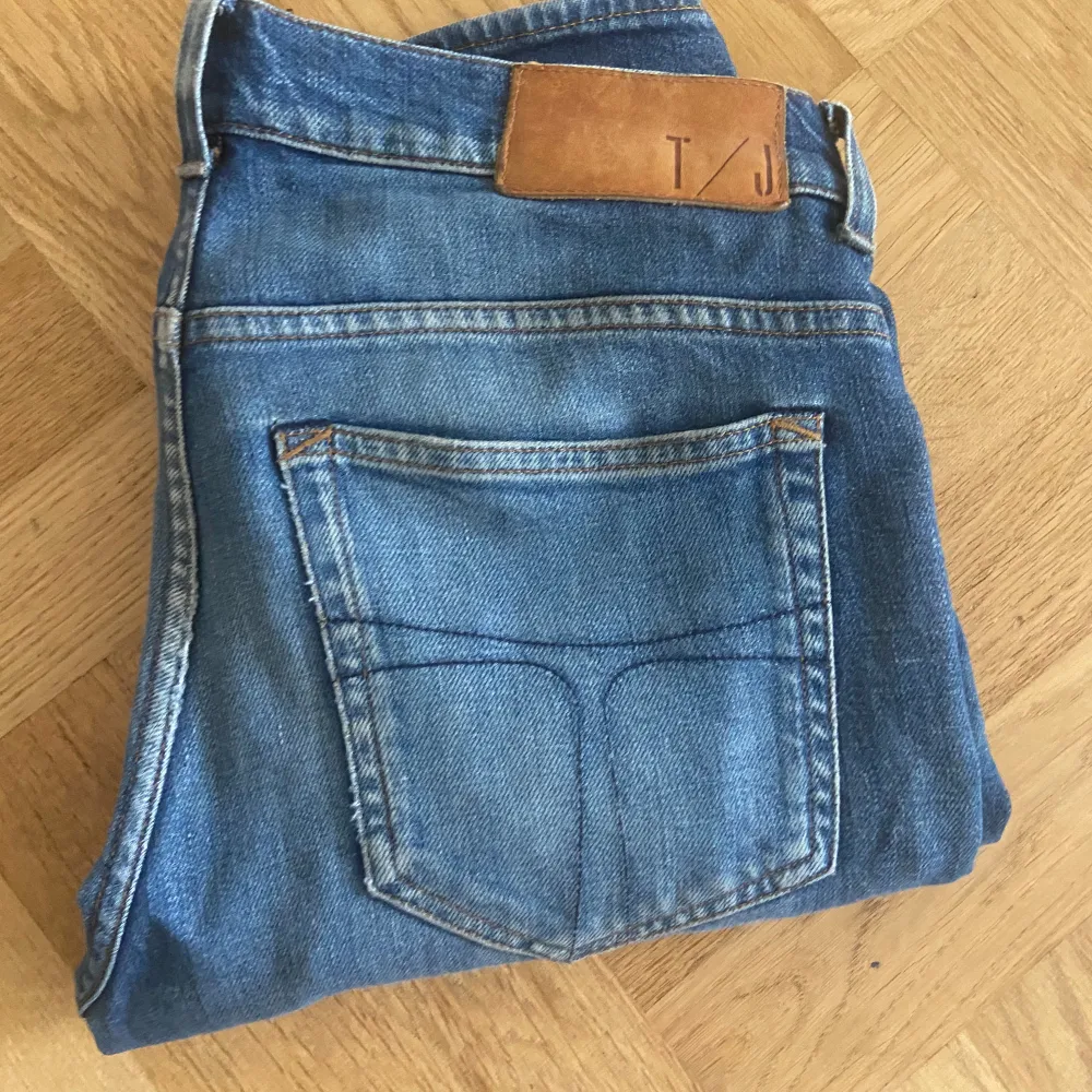 Snygga blå jeans från T/J med en klassisk femficksdesign. De har en normal passform och är perfekta för en avslappnad stil. Jeansen har en läderpatch med logotyp baktill.. Farkut & Housut.