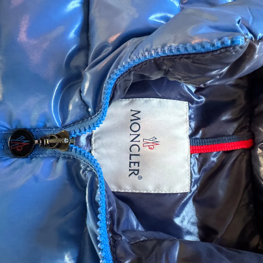 Säljer en snygg blå dunväst från Moncler med dragkedja och hög krage. Perfekt för kyliga dagar när du vill hålla stilen. Västen har en quiltad design och Moncler-logga på bröstet. Hör av er för frågor eller funderingar. Storlek 1. Takit.