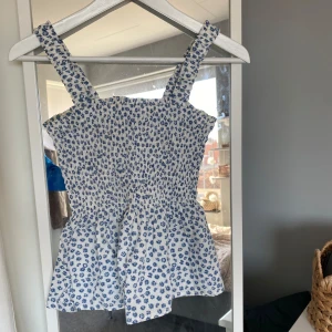 Blommig topp - Söt och somrig blommig topp ifrån Gap. Passar perfekt till sommaren eller våren. Jättefint skick, bara använd några enstaka gånger! Säljer för att den kommer inte till användning längre. 