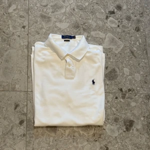 Vit pikétröja från Polo Ralph Lauren - Klassisk vit pikétröja från Polo Ralph Lauren. Ett sjukt bra val för sommaren😇 gjord av bomull och nypriset är cirka 1500kr därav priset