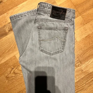  Jacob Cohen jeans grå - Snygga grå jeans från Jacob Cohen med klassisk femficksdesign och knappgylf. Jeansen har en realaxed fitt varken baggy eller tajta midja 32 men skulle säg dom är mer 31 längd