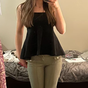 Grå off shoulder topp - Säljer en mörkgrå ärmlös topp (kolla andra bilden för färgen) med utsvängd och flowy passform. Toppen har en enkel design med rak halsringning och är perfekt att styla till olika outfits. Passar till både fest och vardagen💕Aldrig använd!