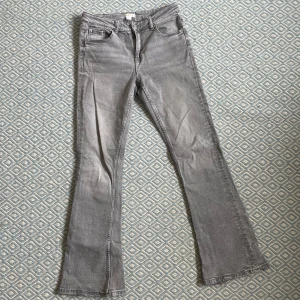 Grå bootcut jeans - Snygga grå jeans med bootcut passform och klassisk femficksdesign. Byxorna har dragkedja och knapp framtill samt subtila slitningar längs benen för en cool look💕 storlek 158