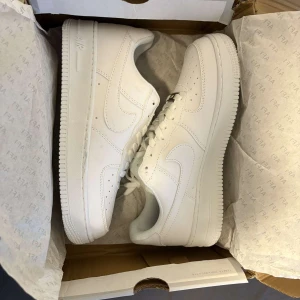 Vita Nike Air Force 1 sneakers - Säljer ett par vita nike air force 1 sneakers. Helt nya aldrig använda innan. Storlek 40