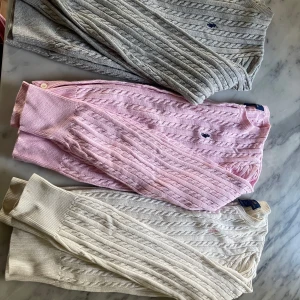 Kabelstickad tröja från Polo Ralph Lauren - Tre kabelstickade tröjor från Polo Ralph Lauren i färgerna grå, rosa och vit. Klassisk design med broderad logga på bröstet och ribbade muddar. Perfekt för dig som gillar tidlös och stilren look. Kostar nya på barnavdelningen 1595kr/styck! Står storlek XL och L men är ju som sagt barnstorlekar och passar därmed 12-14 & 14-16 som det står på bilderna av lapparna. Två av tröjorna är i princip nya, däremot har den vita tröjan en fläck på armen, fråga efter bilder! 