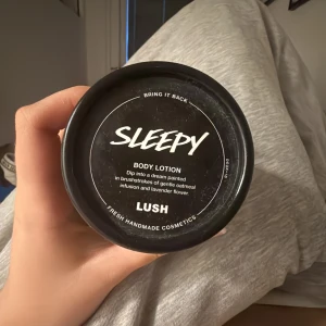 Sleepy Body Lotion från Lush - Sleepy Body Lotion från Lush med doft av lavendel och havre. Kommer i en svart rund burk med vit text och lock. Perfekt för att återfukta huden och ge en lugnande känsla. Doftar otroligt gott 💝
