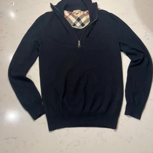 Svart Burberry halvzip-tröja - Tjena, jag säljer min halfzip tröja. Jag har växt ur den o de e därför jag säljer den. Storlek S men passar Xs alltså folk runt 170 cm. Den är helt äkta och det känner man på materialet som är 100% äkta merinoull. Nypris 4500