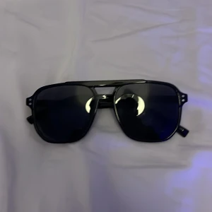 Svarta pilotbågar solglasögon - Snygga svarta solglasögon med pilotbågar och mörka linser. Bågarna är i plast och har en klassisk design med dubbla bryggor. Perfekta för en cool och stilren look.