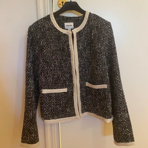 Svartvit kavaj från Kappahl - Säljer en svartvit kavaj från Kappahl med vit kant och två fickor framtill. Jackan har ett klassiskt, elegant snitt och är tillverkad i ett strukturerat tyg med lång ärm. Perfekt för dig som vill ha en stilren look. Köpt för cirka 1 år sedan men aldrig använd då den var väldigt liten i storleken! Är vanligtvis en s/m och jag tyckte den var för trång i ärmarna när jag testa den så skulle säga att den passar ngn med stl xs/s! Köpt för 699kr, prislapp kvar! Säljer den för 399kr