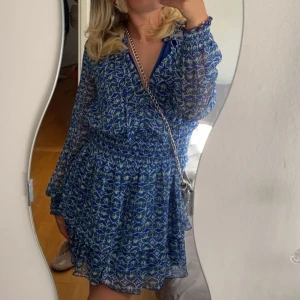 Blå mönstrad klänning med volang från Zara - Säljer en blå kortklänning med vitt och grönt blommönster från Zara i storlek xs🌟knappt använd 