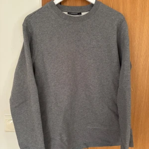 Sweatshirt från J.Lindeberg - Säljer en grå långärmad tröja/sweatshirt från J.Lindeberg. Storlek: M. Hör av dig vid eventuell fråga!