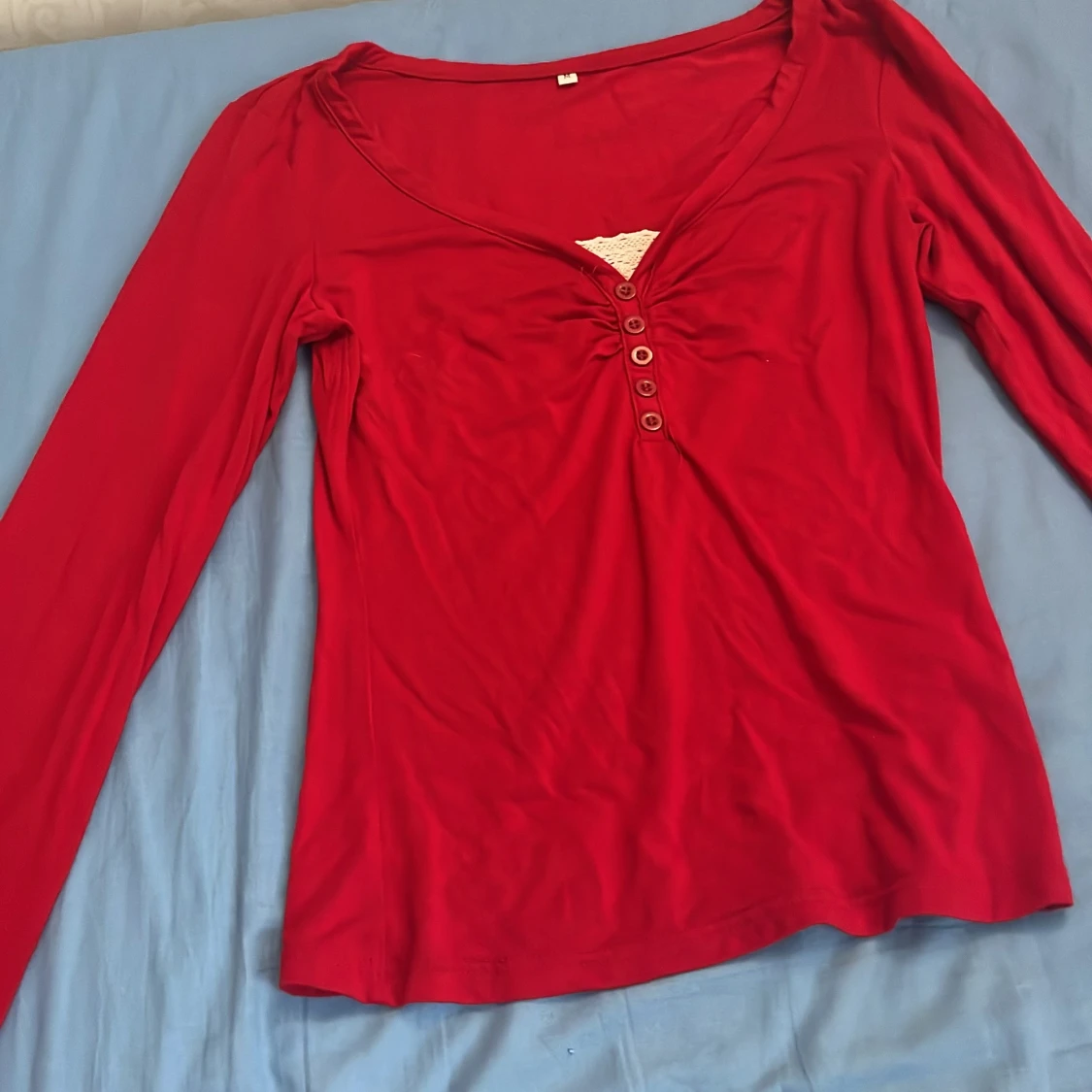 Röd långärmad topp med spetsdetalj