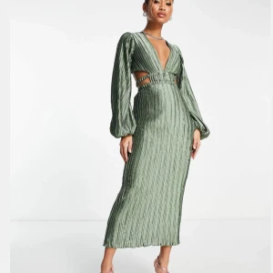 Salviagrön midiklänning - Beställde fel storlek och hann inte returnera den till ASOS. Elegant grön långklänning med puffiga långärmar. Klänningen har en ribbad struktur och utskärningar i midjan. Helt oanvänd med prislapp kvar. Fin till examen eller bröllop. Slutsåld på hemsidan.