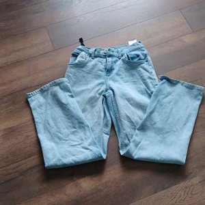 Levi's Stay Loose ljusblå jeans - Säljer ett par ljusblå Levi's Stay Loose jeans med klassisk femficksdesign och raka, vida ben. Jeansen har normal midja och är tillverkade i denim. Perfekta för dig som gillar en avslappnad och trendig stil. Ordinarie pris 849. 