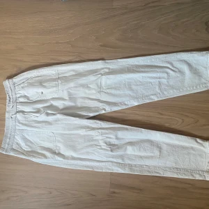 Vita linnebyxor  - Säljer ett par vita linnebyxor med resår i midjan och snörning. Perfekta för varma dagar och en avslappnad stil.