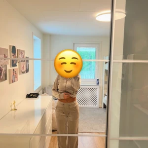 Beige mjukisbyxor i velour och kofta  - Säljer ett par beige mjukisbyxor och kofta i mjuk velour med bred resår och snörning i midjan. Byxorna har raka ben, stora fickor framtill och en chill loose passform. Perfekta för en avslappnad stil och superbekväma att ha på sig.