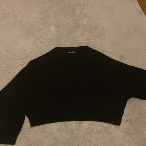 Kort stickad tröja, Storlek L - Croppad stickad tröja från Shein i storlek L men den passar bra på mindre personer också. Det är en tråd som sticker ut i ärmen men annars är den i bra skick. Använd 1 gång.