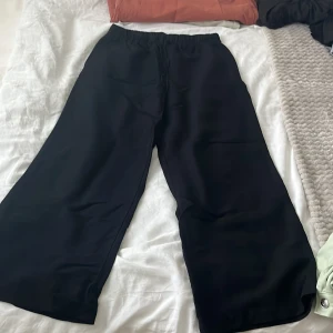 Svarta linne byxor  - Svarta byxor med breda ben och elastisk midja med snörning. Sköna och avslappnade, perfekta för en chill look. Materialet känns mjukt och lätt, passar till många olika outfits.