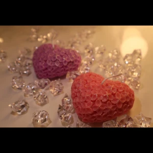 Blooming Heart Candles - Shaped like hearts and covered in delicate floral patterns, these purple and coral-pink candles sparkle with charm. A beautiful gift for someone you love-or a sweet treat for yourself.