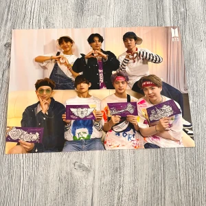 BTS - Färgstark poster med BTS, perfekt för fans! Innehåller bilder på medlemmarna i avslappnad och kreativ miljö, där de håller konstnärliga kort. En samlarfavorit för dig som älskar K-pop och vill ha något unikt.